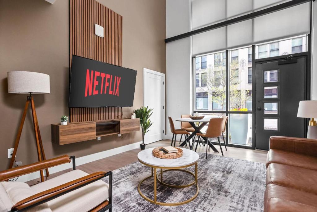 un soggiorno con tv e tavolo di Downtown Townhome Game Room with Pool, Parking, Gym a Indianapolis