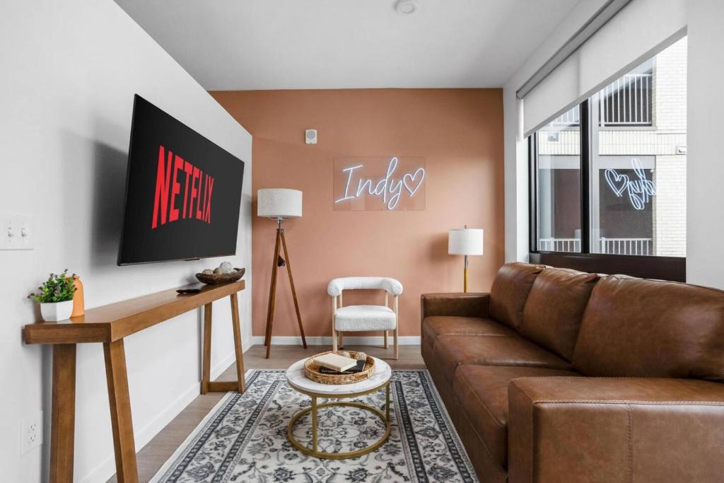 een woonkamer met een bank en een tafel bij The Indy Suite High-Rise Condo with Pool, Gym, Parking in Indianapolis