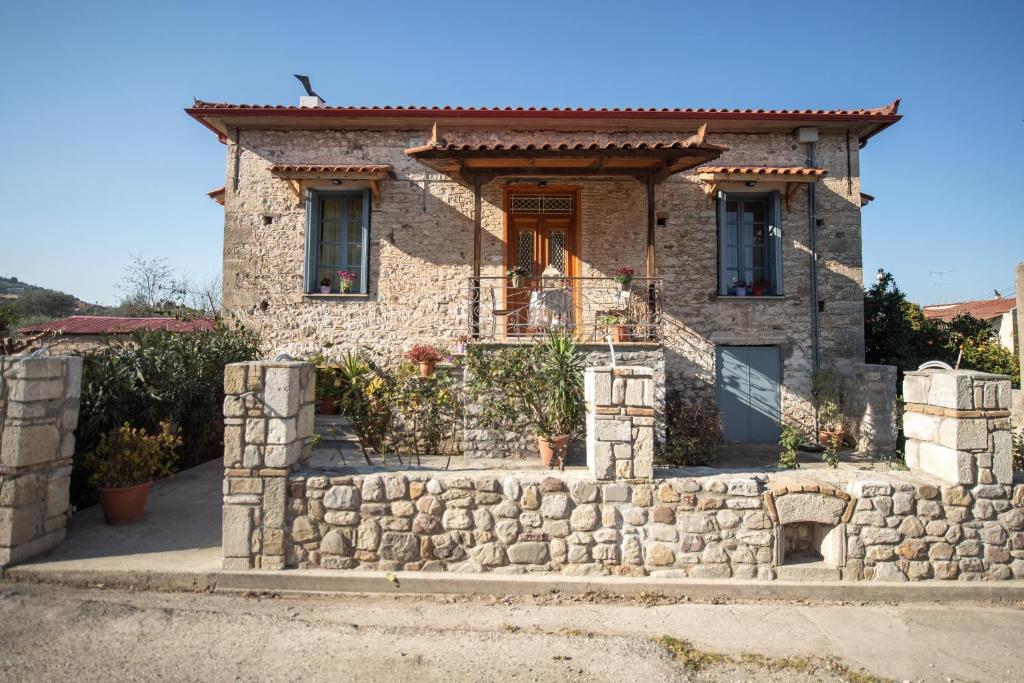 une maison en pierre avec un mur en pierre dans l'établissement Σπίτι στο Χωριό - Les campagnards, à Rodhodháfni