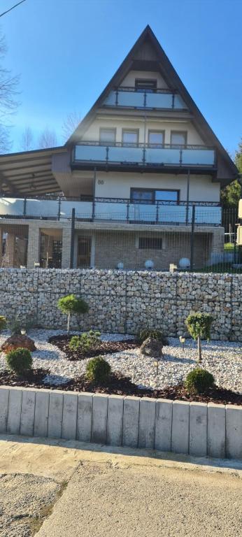 BžanyChata Domaša David的院子中一座有石墙和树木的房子