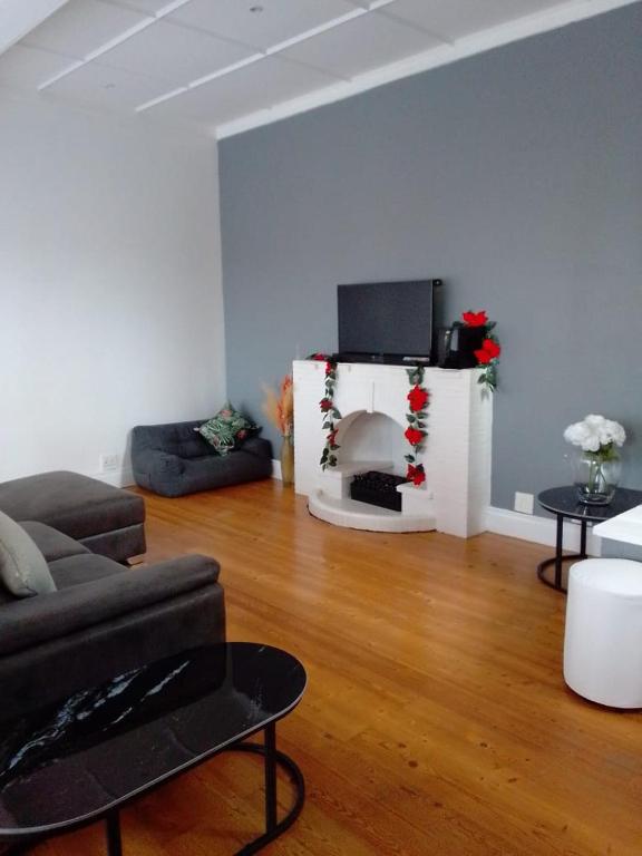een woonkamer met een bank en een tv bij Holland Manor in Durban
