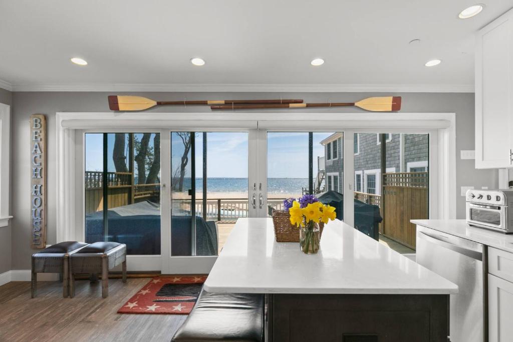 a kitchen with a counter with a view of the ocean at Modern Beachfront Escape - Steps from Ferry - Deck in Provincetown