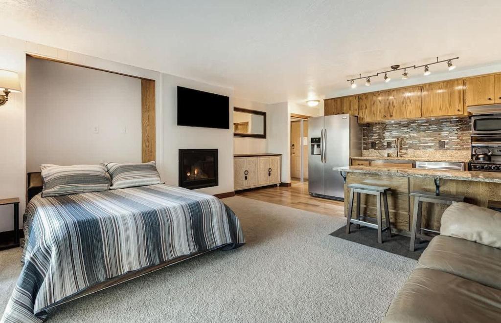 a large bedroom with a bed and a kitchen at Ground Floor - Riverfront Studio in Bend
