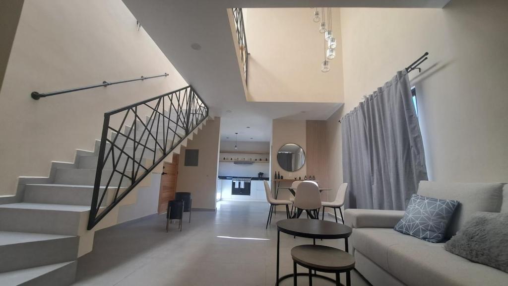 un soggiorno con un divano e una scala di Casa Cielo a Todos los Santos