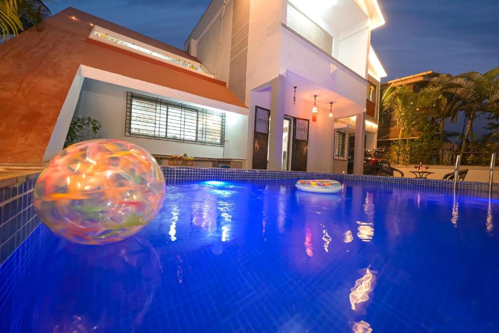 ein Schwimmbecken mit einem Ball vor einem Haus in der Unterkunft ll EMPYREAN STAY ll 3BHK ll CELESTIAL UNICORN VILLA ll AC ll PRIVATE POOL ll LUXURY ll in Lonavla