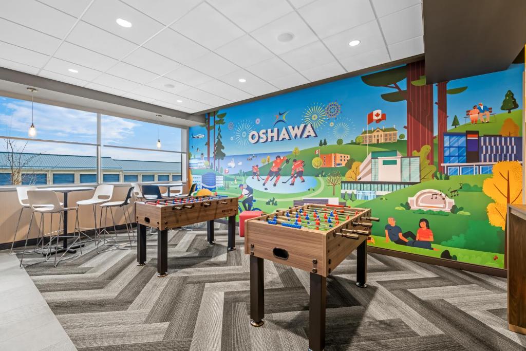 a childrens play room with two tables and a mural at Tru By Hilton Oshawa in Oshawa