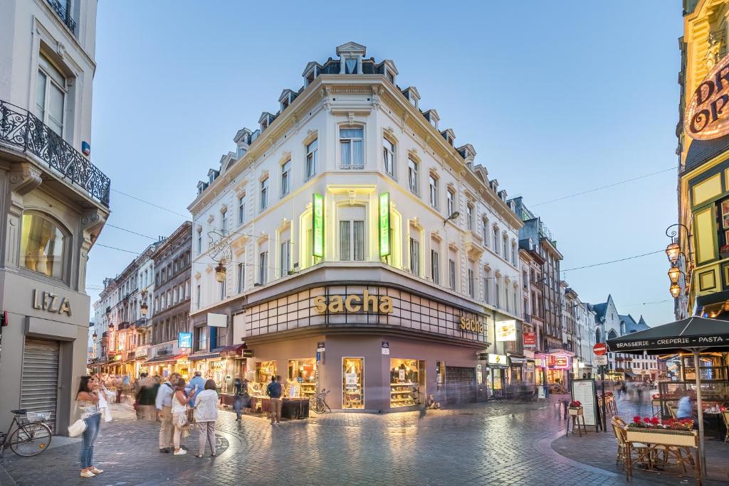 een groep mensen die door een straat lopen met een gebouw bij Safestay Brussels Grand Place in Brussel