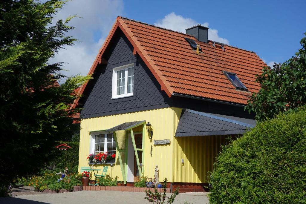 een geel en zwart huis met een rood dak bij Ferienwohnung Dorle in Benneckenstein