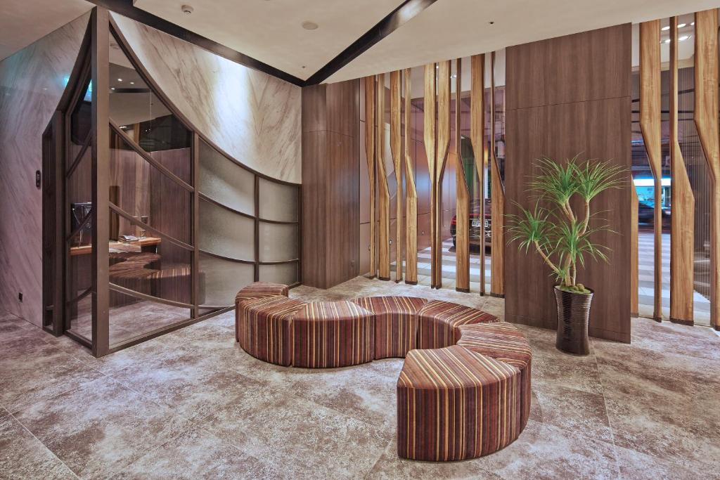 a living room with a circular couch and a plant at La Vida Hotel in Taichung