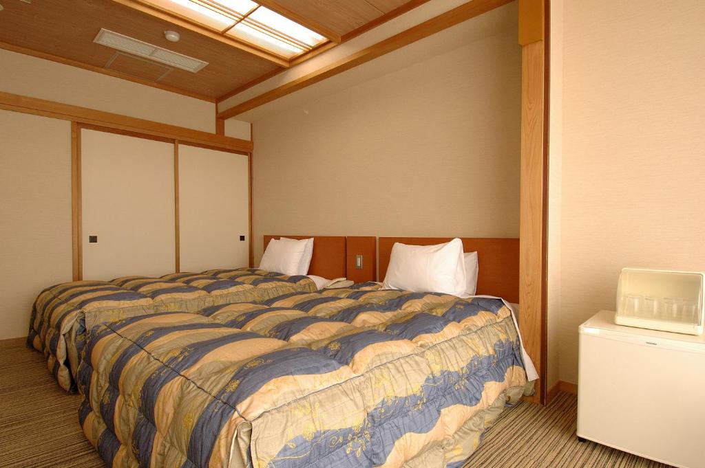 Postel nebo postele na pokoji v ubytování Zekkeino Yado Inubohsaki Hotel