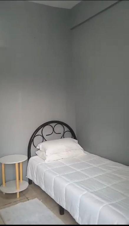 a bed with a white blanket and a table at Casa Dwayne room 102 in Cebu City