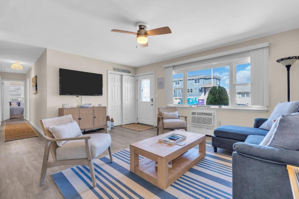a living room with a couch and chairs and a tv at 209 4th Ave in Seaside Heights