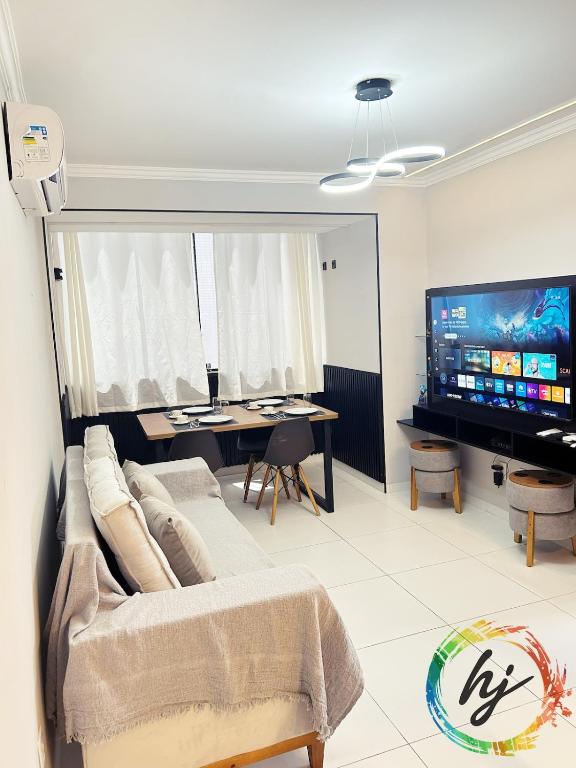 een woonkamer met een bank en een tv bij Atria 304 in Tambaú
