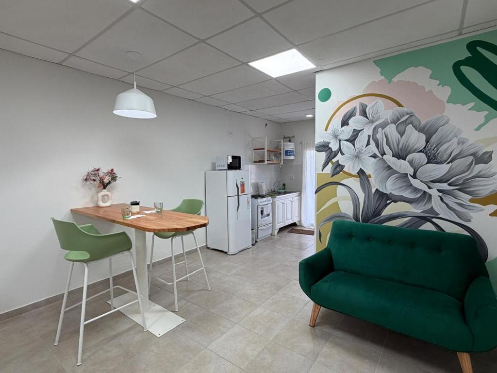 a living room with a table and a green couch at Departamentosenchascomus in Chascomús