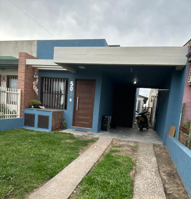 a small blue house with a garage at Casa de Praia in Capão da Canoa