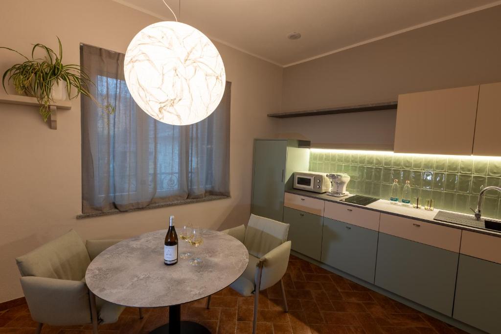 a kitchen with a table with a bottle of wine on it at Nidin Apartments in Cassano Spinola