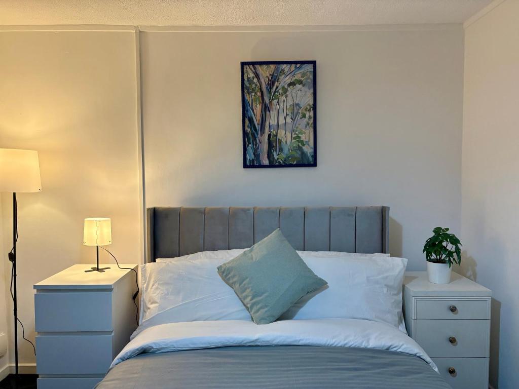 a bedroom with a bed with a picture on the wall at Bright and Spacious 2 Bed Flat Sleeps 5 in Nottingham