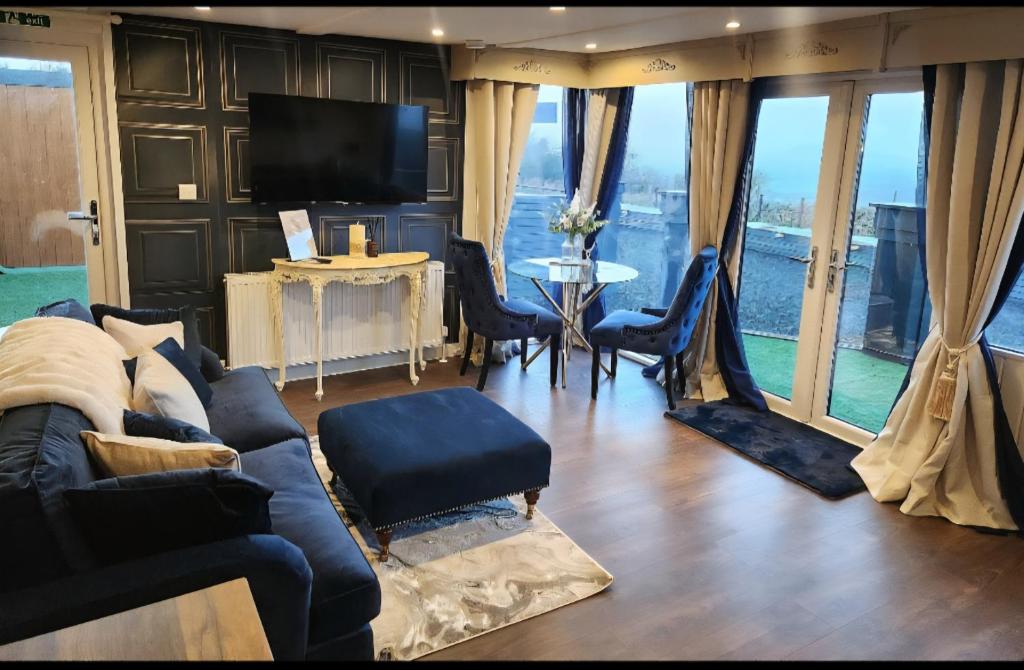 a living room with a couch and a table with chairs at Mary Queen of Scots Lodge in Musselburgh