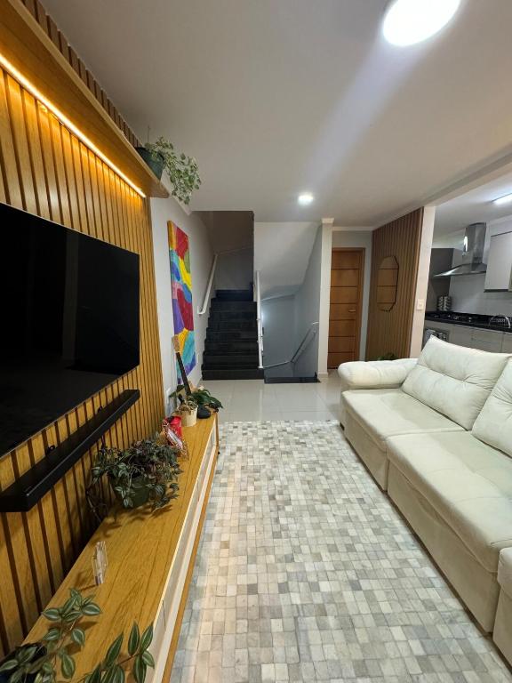 een woonkamer met een bank en een flatscreen-tv bij Triplex in Village - Santos SP in Santos