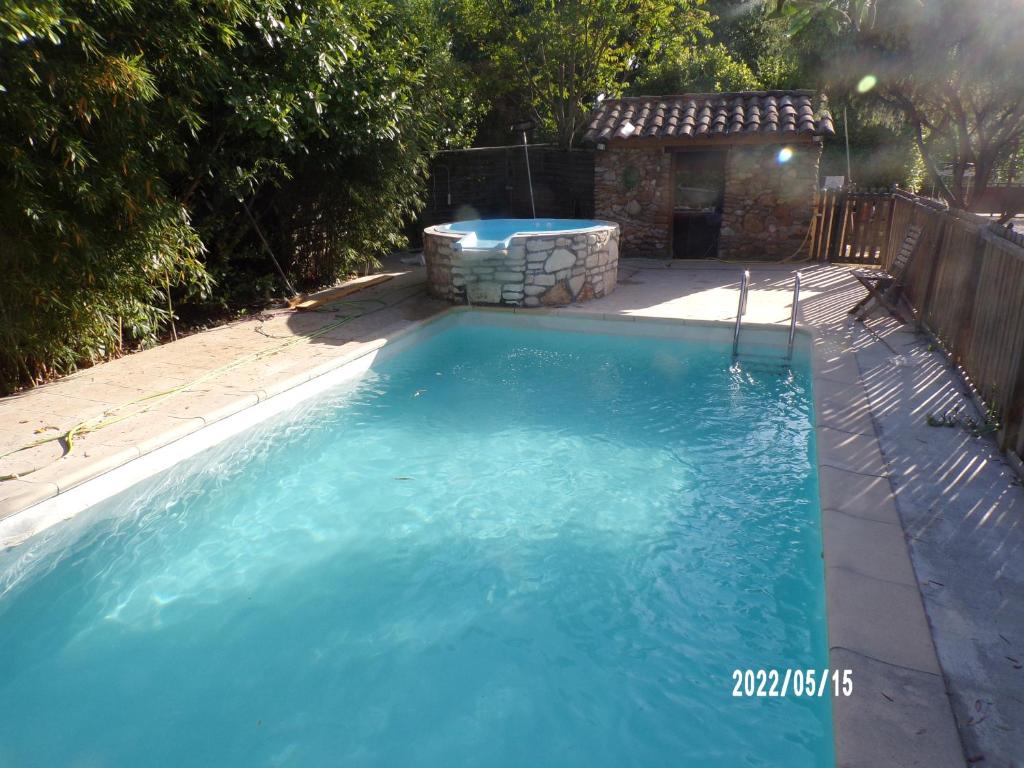 une piscine avec de l'eau bleue dans une cour arrière dans l'établissement Le Mas Hauregard, à La Celle-sous-Gouzon
