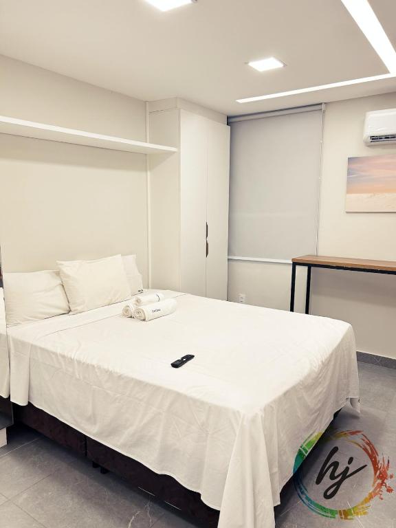 ein Schlafzimmer mit einem weißen Bett und einem Telefon darauf in der Unterkunft Maison Saint Remy 209 in Tambaú