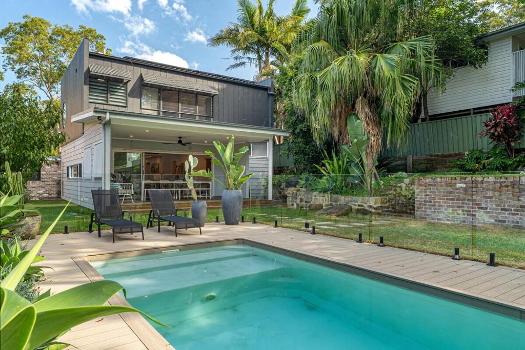 a backyard with a swimming pool and a house at Bundeena Bungalow in Bundeena
