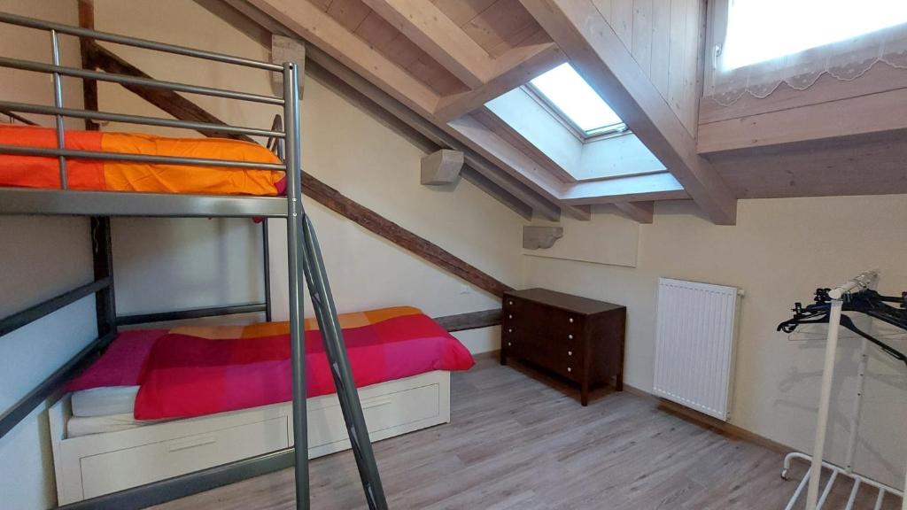 een slaapkamer met 2 stapelbedden en een dakraam bij Casa Mia in Agordo