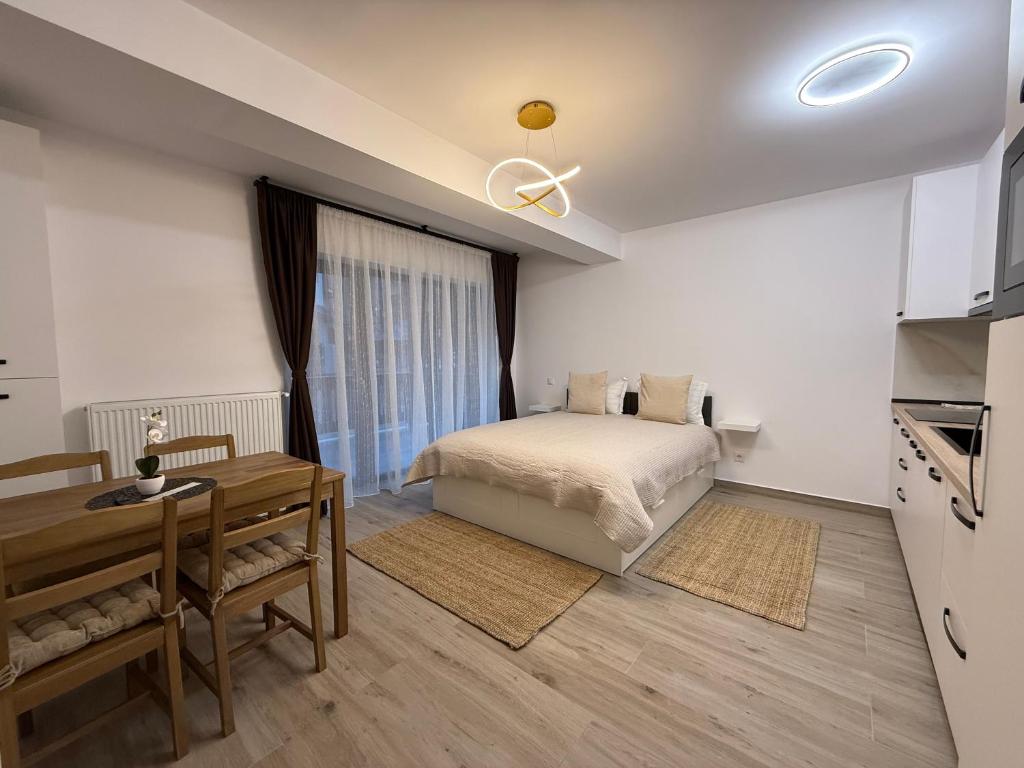 a bedroom with a bed and a table and a kitchen at The View Studio 2 Busteni in Buşteni