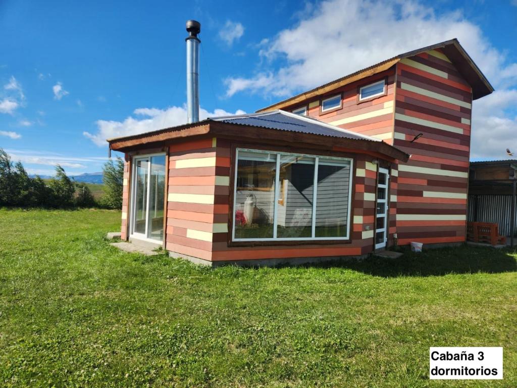 a tiny house on a grassy field at Turismo Raíces in Coihaique