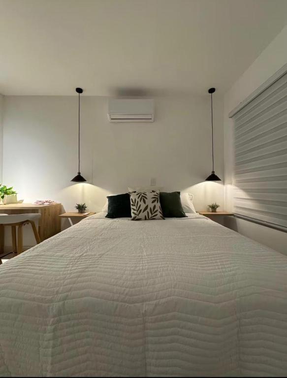 a bedroom with a large white bed with two pillows at Aparta estudio Luxury in Cali