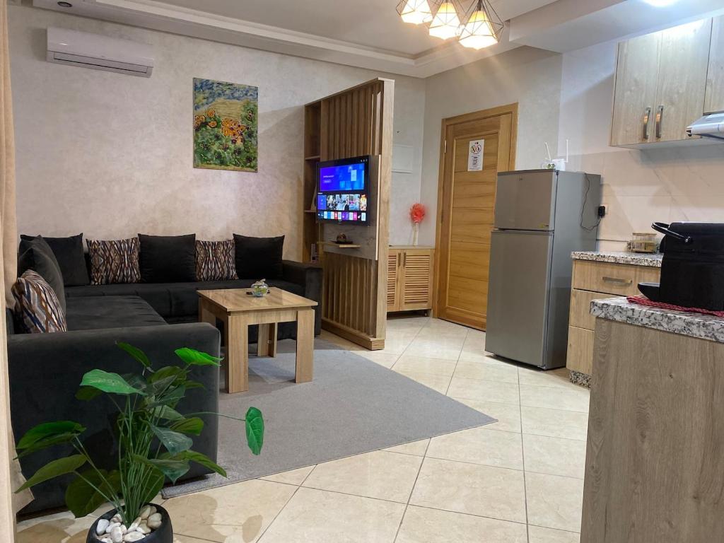 ein Wohnzimmer mit Couch und Kühlschrank in der Unterkunft F2 Luxury & Light in Oulad Akkou
