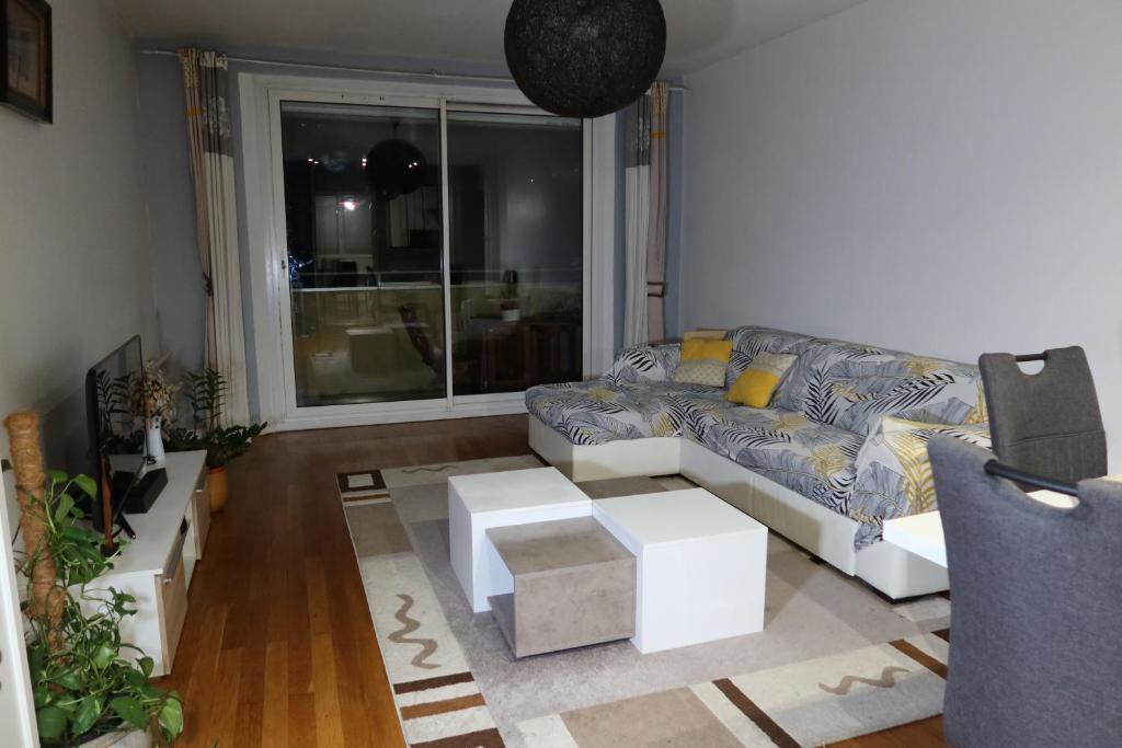 a living room with a couch and a table at Chambre privée dans bel appartement lumineux in Lyon