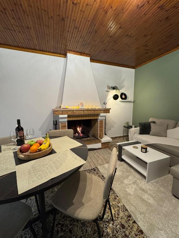 a living room with a table and a fireplace at Eftychia's House in Marioláta
