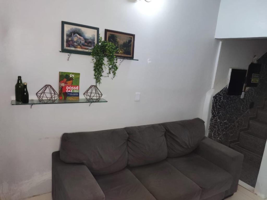 ein Wohnzimmer mit einem braunen Sofa vor einer weißen Wand in der Unterkunft Hotel Tunísia - Gama in Brasilia