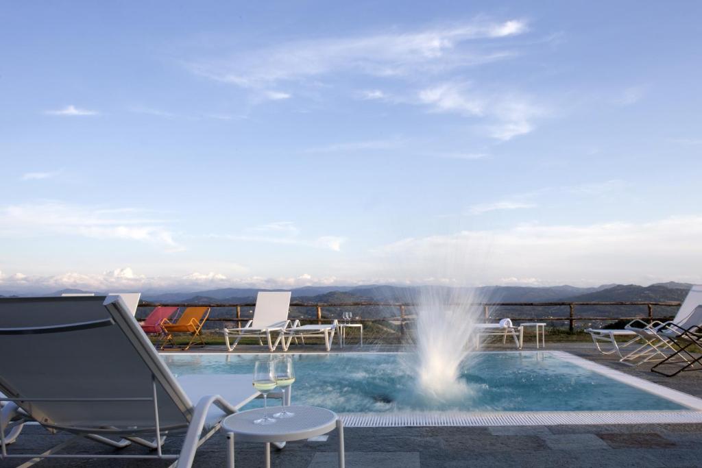 a view of a pool with chairs and a fountain at Cascina Marcantonio in Acqui Terme