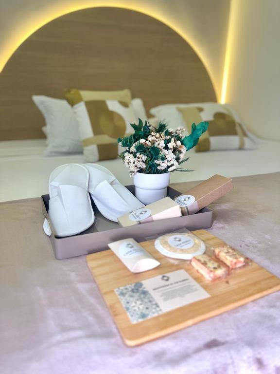 un tavolo con scarpe e un vaso di fiori di Hotel Boutique Casa Kereht by Mekedo a Cali