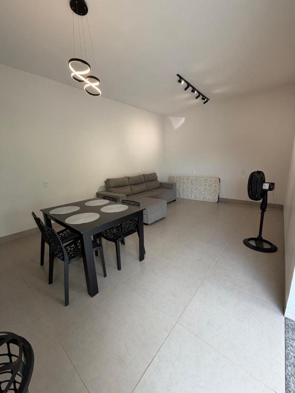 a living room with a table and a couch at Casa aconchegante com 02 quartos climatizados in Nova Mutum