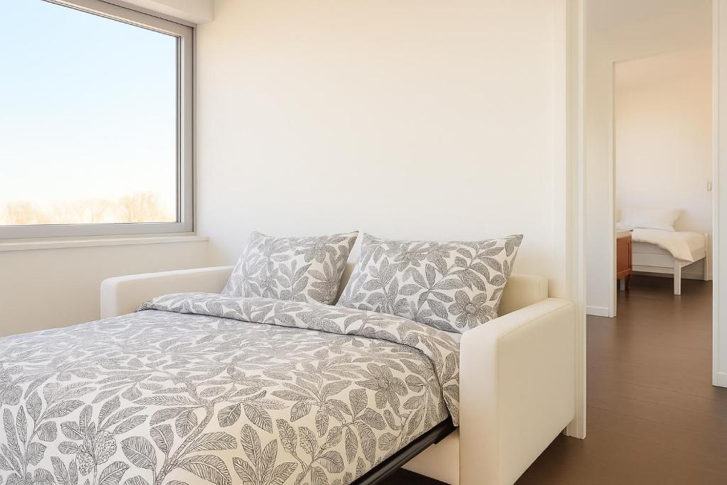 een witte bank in een kamer met een raam bij Douce escale - T3 d exception face mer in Saint-Jean-de-Monts