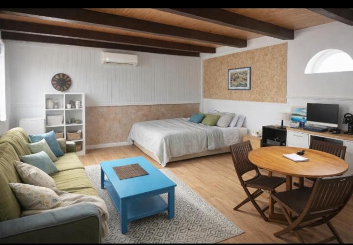 ein Wohnzimmer mit einer Couch, einem Bett und einem Tisch in der Unterkunft Meloneras Maspalomas Pasito Blanco in Pasito Blanco