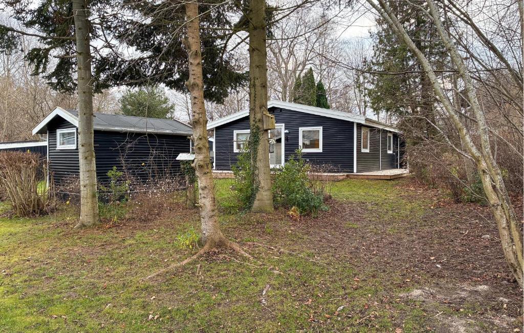 ein Haus inmitten eines Hofes mit Bäumen in der Unterkunft Beautiful Home In Dronningmølle With Wifi in Hulerød