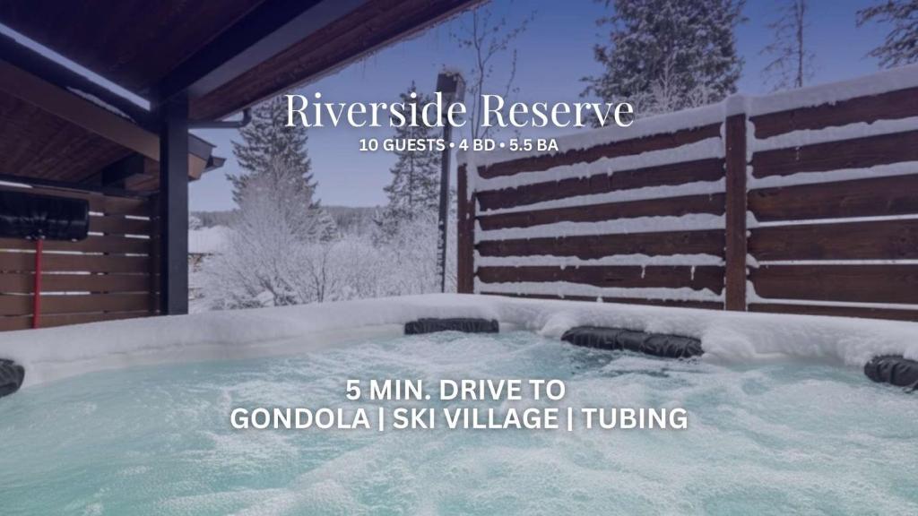 una vasca idromassaggio coperta di neve accanto a una recinzione di Riverside Reserve a Winter Park