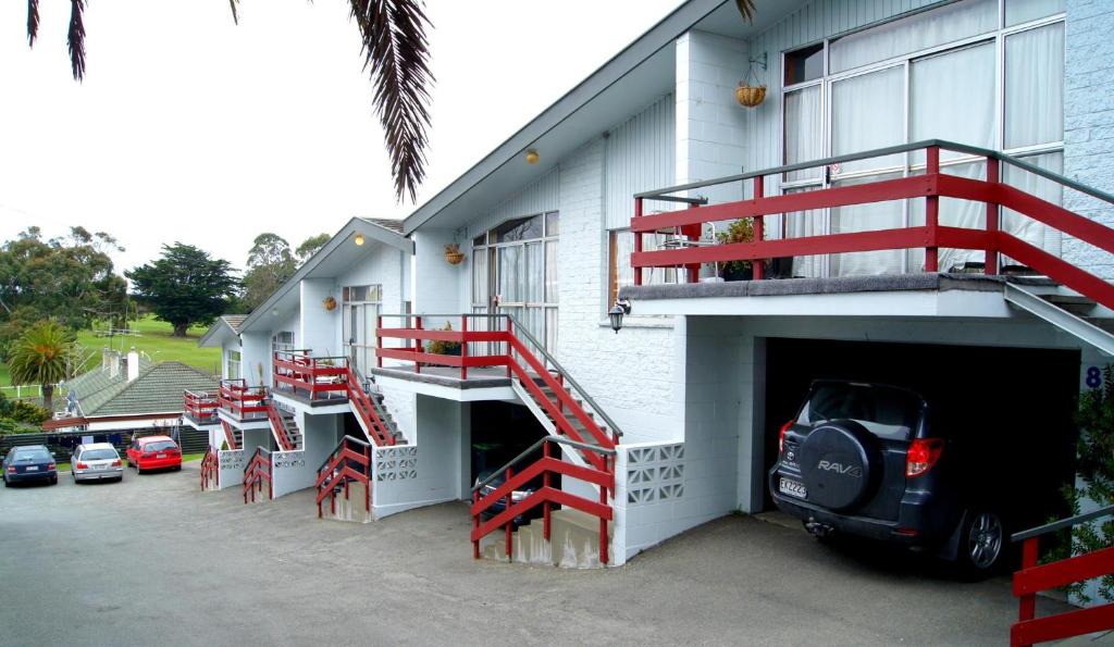 un edificio con escaleras rojas en su lateral en Aaron Court Motel, en Timaru