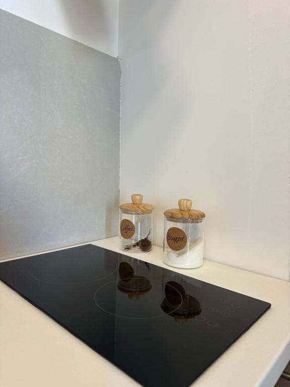 Twee bakjes staan op een tafel met een zwart tapijt. bij Apartman 2937 in Podgorica