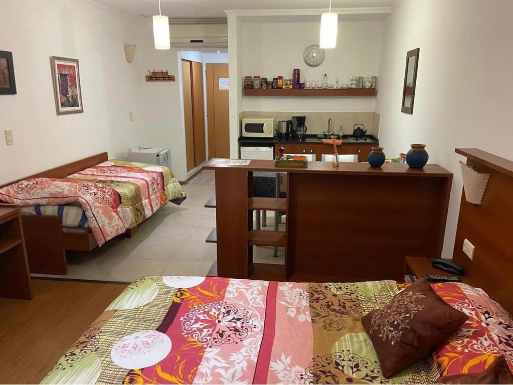 una camera con due letti e una cucina di Edificio Colina 1 a Victoria