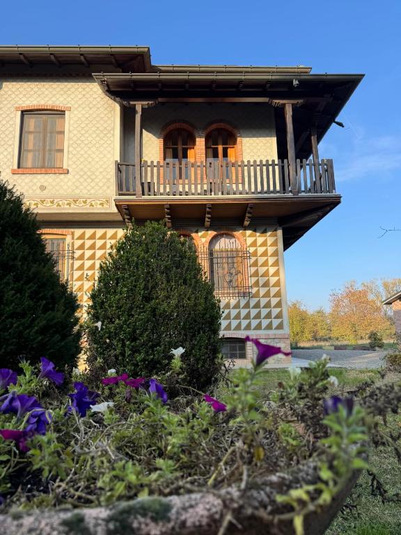 a house with a balcony and flowers in front of it at beb MUFFIN in Grazzano Visconti