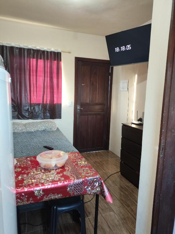 a small room with a table and a bed at Loft Praia da Vila in Imbituba
