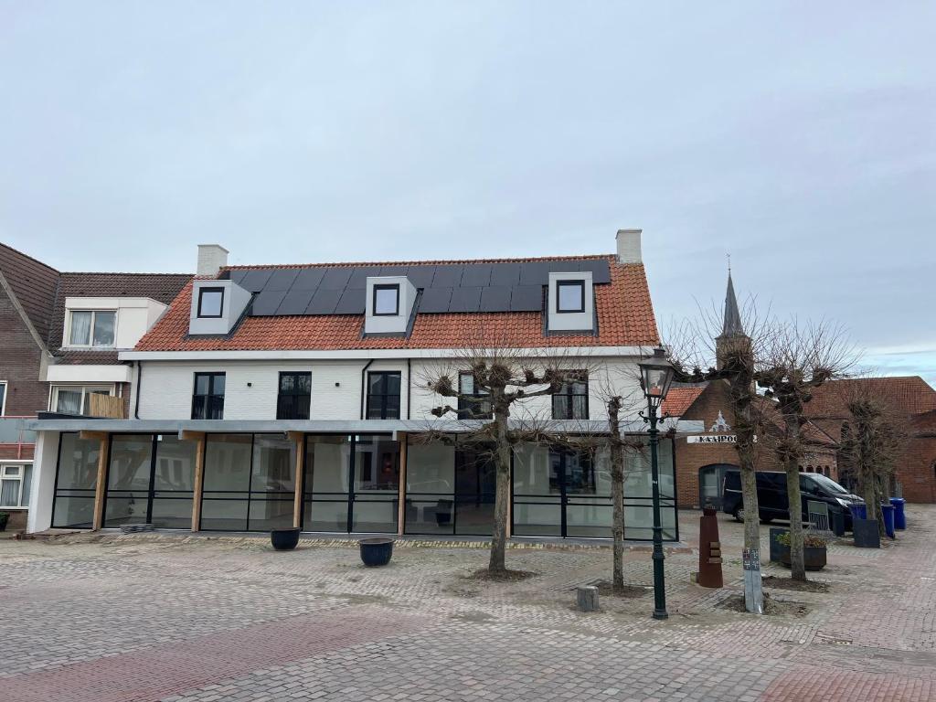 un bâtiment avec beaucoup de fenêtres sur une rue dans l'établissement Hotel Aardenburg, à Aardenburg