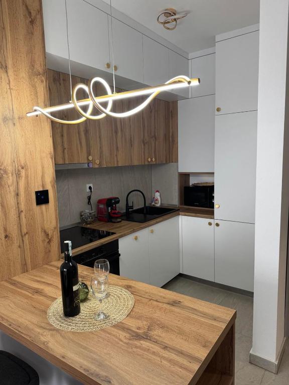 a kitchen with a wooden table with a bottle of wine at Cozy apartment Banja Luka in Budžak