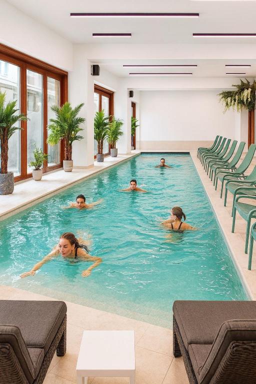 a group of people swimming in a swimming pool at Hotel&SPA 5 HILLS DRAGASANI in Drăgăşani
