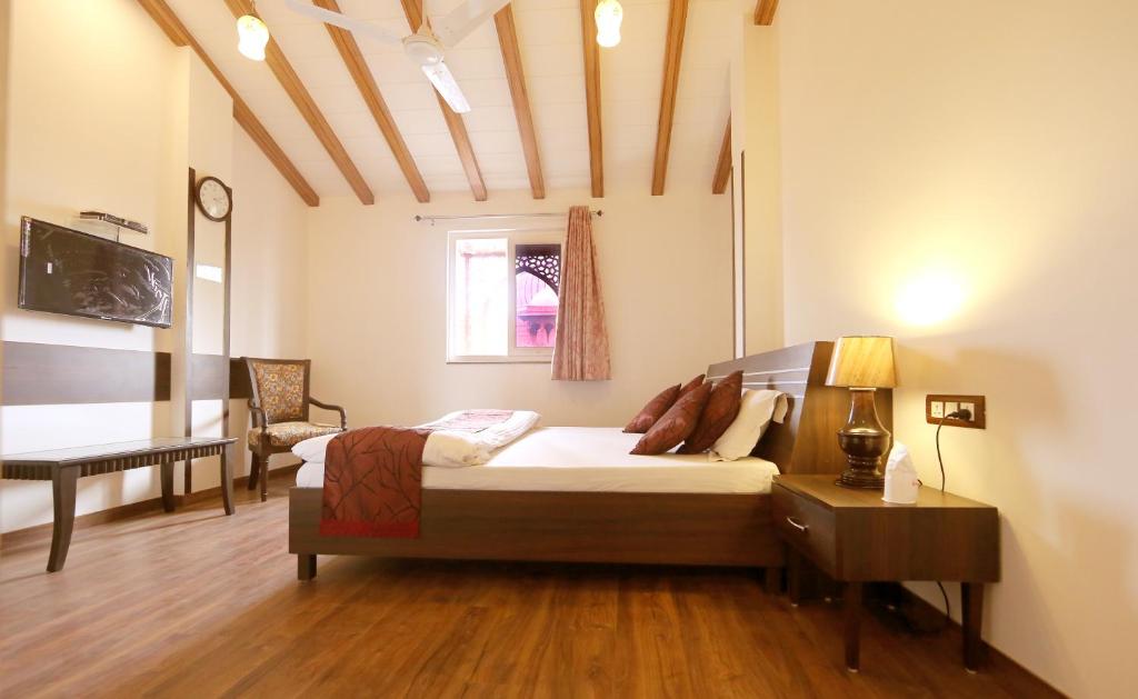 a bedroom with a bed and a desk in a room at Hotel Aiwan-e-Shahi in New Delhi